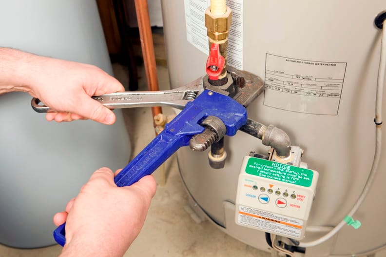 Plumber repairing water heater pipe connection in Danville, California home