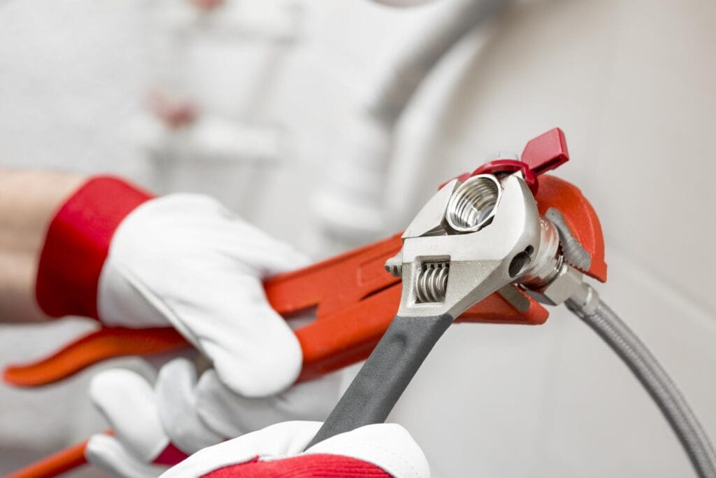 Plumber tightening pipe fitting for residential plumbing repair in Danville, California
