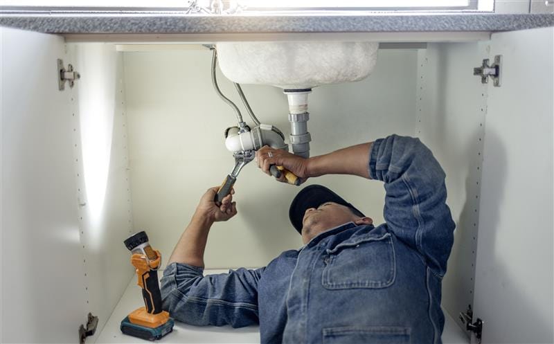 Plumber repairing kitchen sink drain pipes in Danville, California