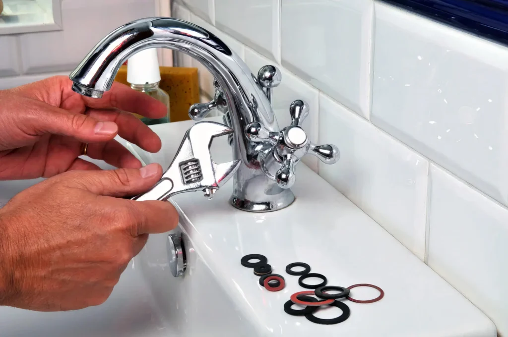 Plumber performing maintenance on a bathroom faucet in Danville