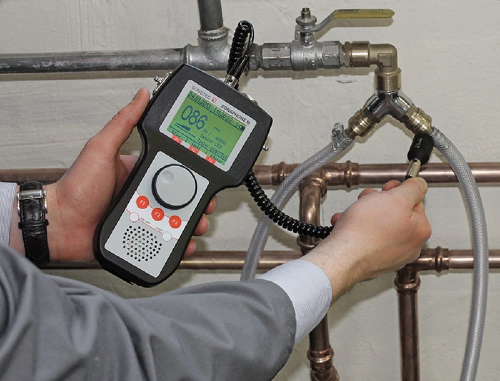 Plumber testing pipes with electronic leak detection equipment in Danville
