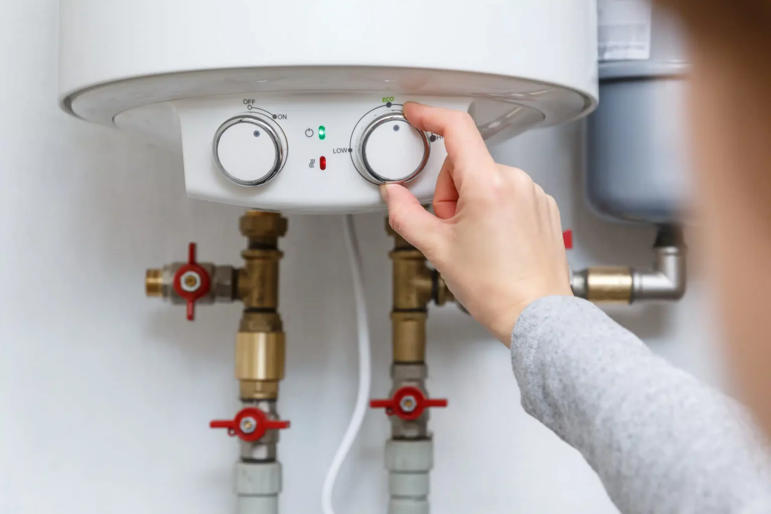 Homeowner adjusting the temperature controls on a water heater in Danville